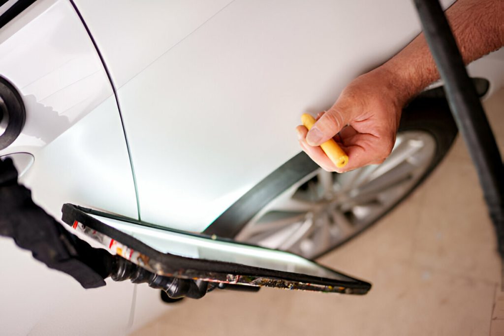 : "A car owner filing an insurance claim for paintless dent repair."