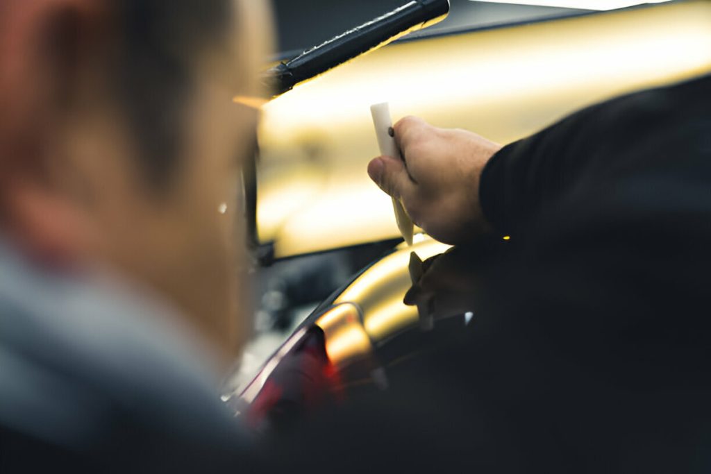 "A skilled technician using specialized tools to perform PDR on a vehicle.
