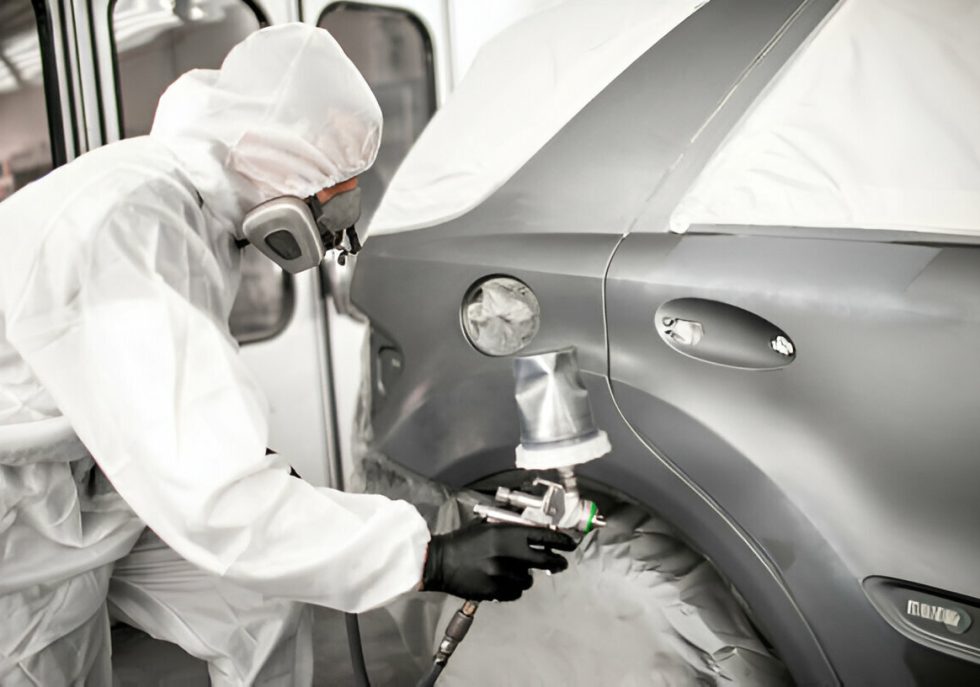 "A technician demonstrating paintless dent repair on a car."